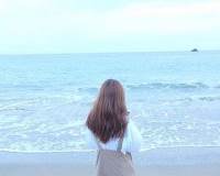 坐在海滩上的孤单女生背影唯美图片